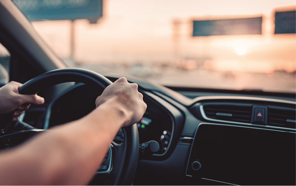 Close-up - Hand of man driving car on the road.
